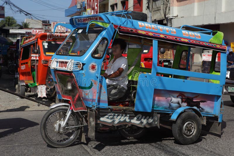 Southeast-Asian motorela in action on city street. A motorela (motorcycle + caretela) is a unique form of local short haul public transportation made up of a detachable motorcycle with an oversized cabin grafted to the rear. It can seat up to 10 passengers. Around Cogon Market, Cagayan de Oro City, Mindanao, Philippines, on Dec 3, 2009, at 1:45pm. Southeast-Asian motorela in action on city street. A motorela (motorcycle + caretela) is a unique form of local short haul public transportation made up of a detachable motorcycle with an oversized cabin grafted to the rear. It can seat up to 10 passengers. Around Cogon Market, Cagayan de Oro City, Mindanao, Philippines, on Dec 3, 2009, at 1:45pm.