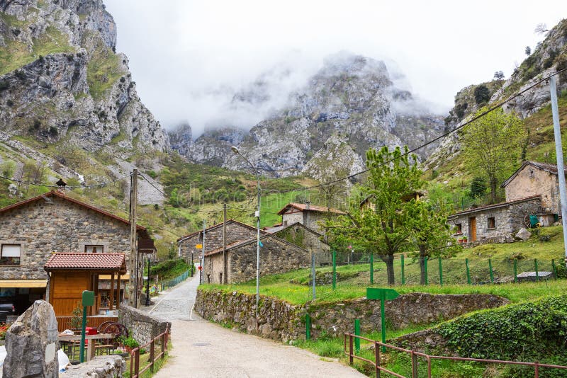 Улица с старыми типичными домами в пасмурных весеннем дне, Каине de Valdeon, Picos de Европе, Кастили и Леоне, Испании Каин вилла стоковые изображения rf