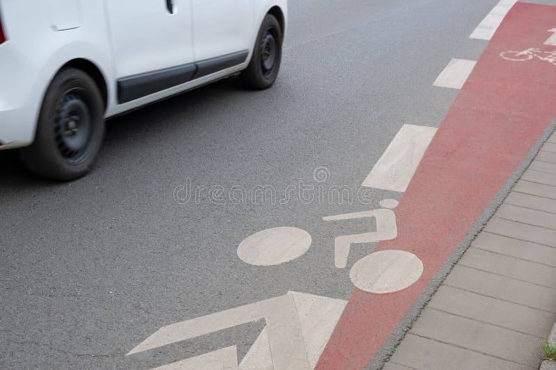 Street markings by paint on asphalt denote a dedicated bike lane in the city, enhancing safety for cyclists amidst urban traffic. Street markings by paint on asphalt denote a dedicated bike lane in the city, enhancing safety for cyclists amidst urban traffic