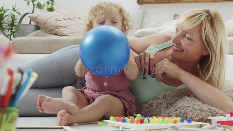 улыбающаяся мать с блондинкой-кудрявой дочкой дошкольное обучение в семье концепция здорового роста