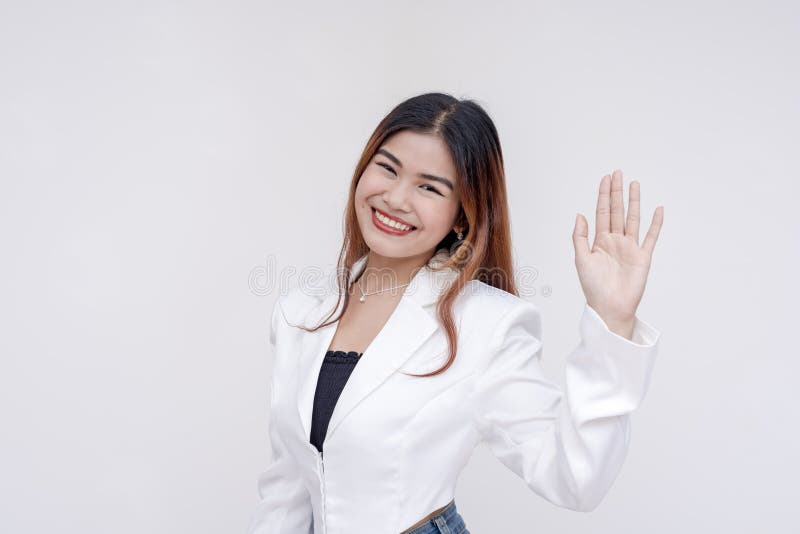 A smiling young woman with left hand raised as an act of taking oath. Isolated on a white background. A smiling young woman with left hand raised as an act of taking oath. Isolated on a white background.