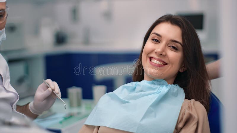 Улыбаясь пациент женщины стоматологии после лечения зубов. Снимок на красной камере кино ворона 4k