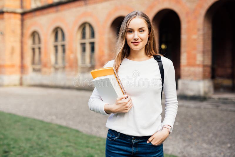 Умный женский студент колледжа с сумкой и книги на кампусе outdoors стоковое изображение rf Умный женский студент колледжа с сумкой и книги на кампусе outdoors стоковое изображение rf