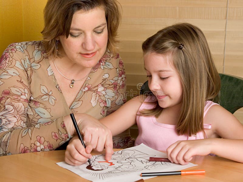 A woman teaching a little girl about Jesus, as the girl colors a picture of him (could be Sunday School image). A woman teaching a little girl about Jesus, as the girl colors a picture of him (could be Sunday School image)