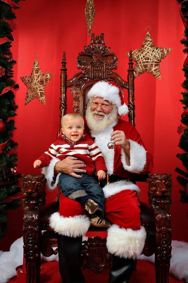 Baby boy sitting on Santa's lap at Christmas time. Baby boy sitting on Santa's lap at Christmas time.