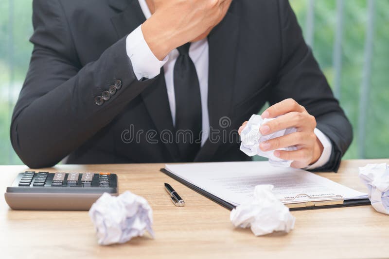 Stressed businessman crumple paper with calculator and contract document - making a mistake concept. Stressed businessman crumple paper with calculator and contract document - making a mistake concept