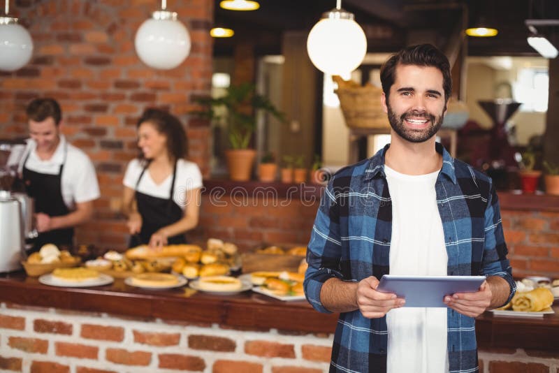 Усмехаясь битник используя таблетку перед работая barista стоковые фотографии rf