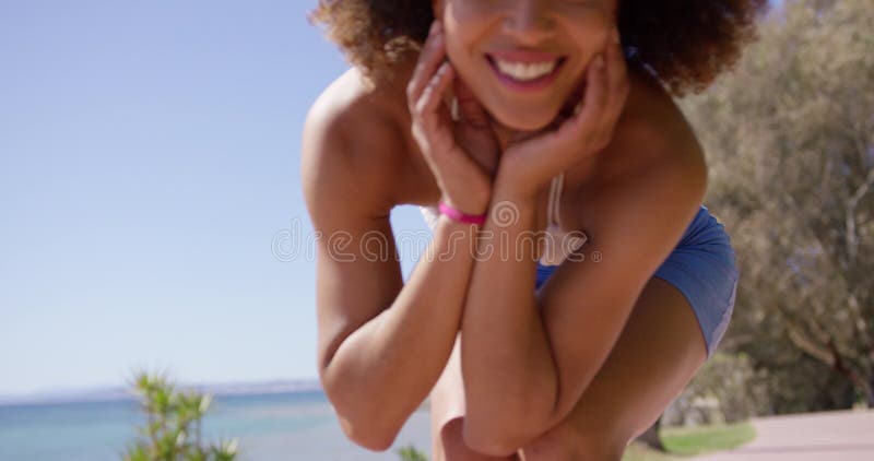 Усмехаясь девушка представляя на пляже акции видеоматериалы