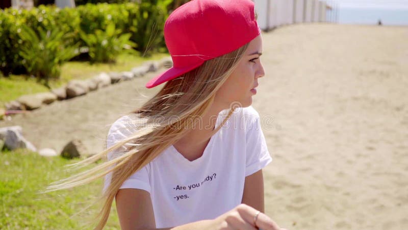 Усмехаясь женские друзья сидят на стене около пляжа сток-видео