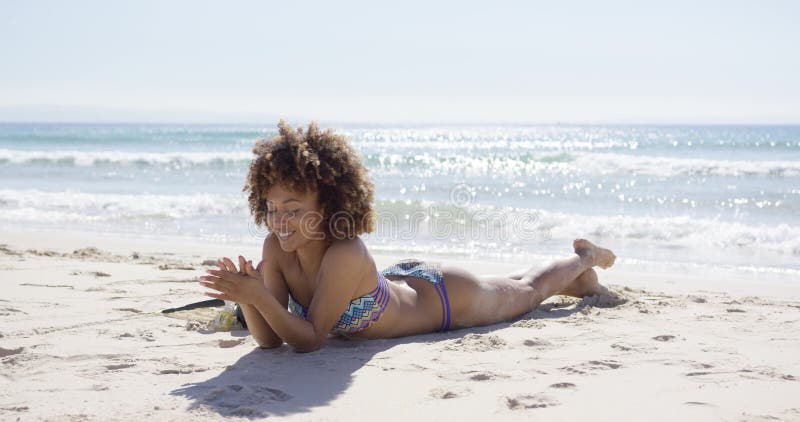 Усмехаясь женский загорать на пляже сток-видео