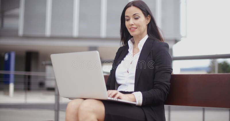 Усмехаясь женский работник с компьтер-книжкой на стенде акции видеоматериалы