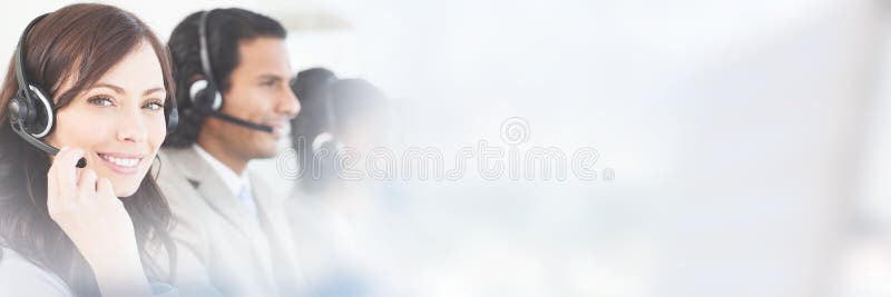Усмехаясь работник работая с шлемофоном пока смотрящ камеру стоковое фото Усмехаясь работник работая с шлемофоном пока смотрящ камеру стоковое фото