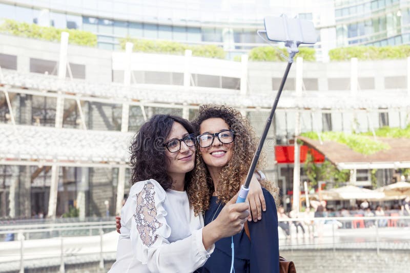 2 усмехаясь симпатичных девушки принимают selfie с smartphone стоковое фото rf