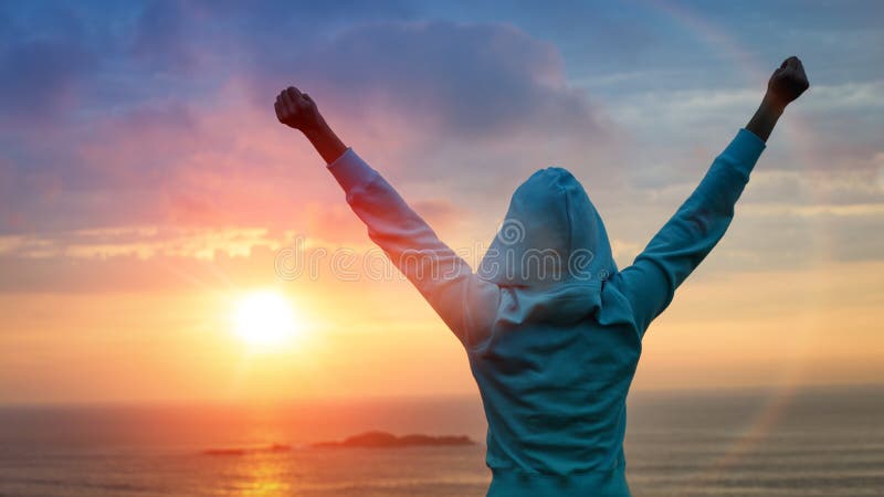 Sport and life achievements and success concept. Rear view sporty girl raising arms towards beautiful glowing sunshine. Sport and life achievements and success concept. Rear view sporty girl raising arms towards beautiful glowing sunshine.