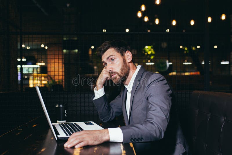 успешный бизнесмен, работающий на ноутбуке во время обеденного перерыва, сидящий в ресторане отеля, устал выполнять задачи стоковые фотографии rf