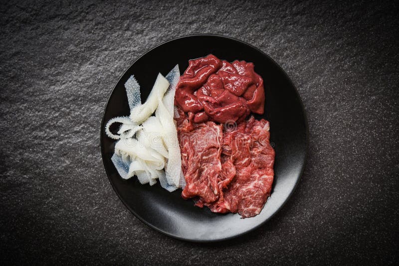 Установите куска и печени говядины мяса на предпосылке черной плиты темной для кухни сваренной или Sukiyaki Shabu shabu японской стоковые фотографии rf Установите куска и печени говядины мяса на предпосылке черной плиты темной для кухни сваренной или Sukiyaki Shabu shabu японской стоковые фотографии rf