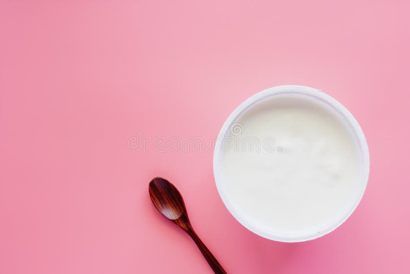 Установите югурт, естественный вкус и деревянную ложку на розовом пастельном colo стоковое изображение rf Установите югурт, естественный вкус и деревянную ложку на розовом пастельном colo стоковое изображение rf