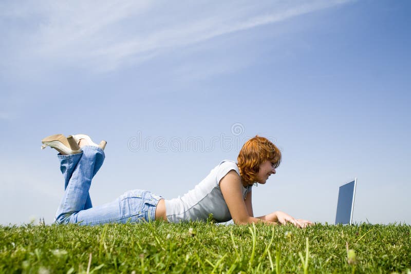 Young girl with laptop on the grass (2). Young girl with laptop on the grass (2)