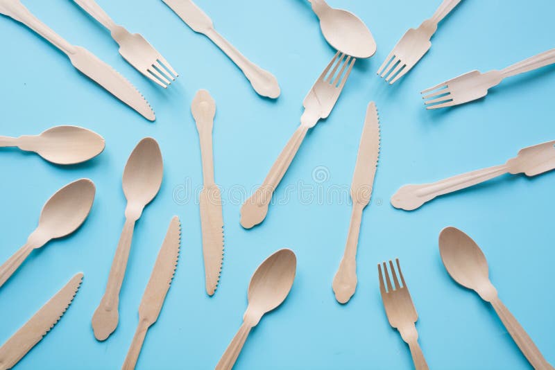 Устранимый tableware от естественных деревянных материалов, ложки, ножа, и вилки, дружественной к эко для пикника на сини r стоковые изображения rf Устранимый tableware от естественных деревянных материалов, ложки, ножа, и вилки, дружественной к эко для пикника на сини r стоковые изображения rf