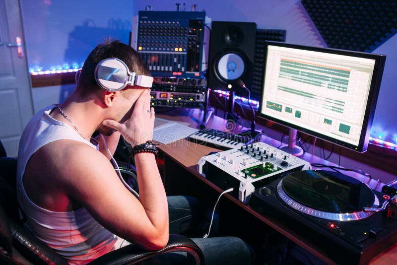 Утомленный DJ после дополнительного времени в студии стоковое фото rf Утомленный DJ после дополнительного времени в студии стоковое фото rf