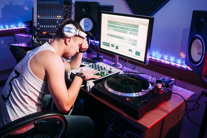 Утомленный DJ после дополнительного времени в студии стоковые изображения rf Утомленный DJ после дополнительного времени в студии стоковые изображения rf