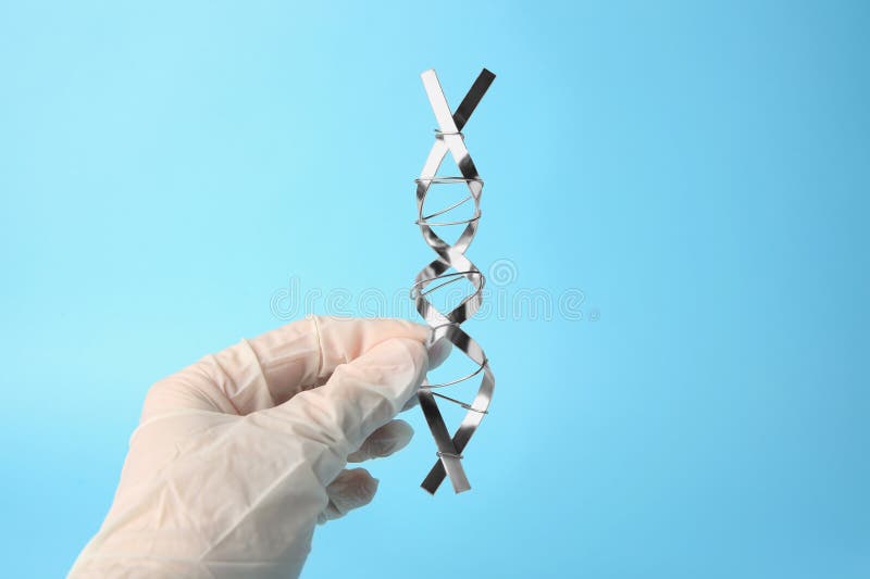 ученый с молекулярной цепной моделью dna, сделанной из металла на светло-синем фоне стоковые фото
