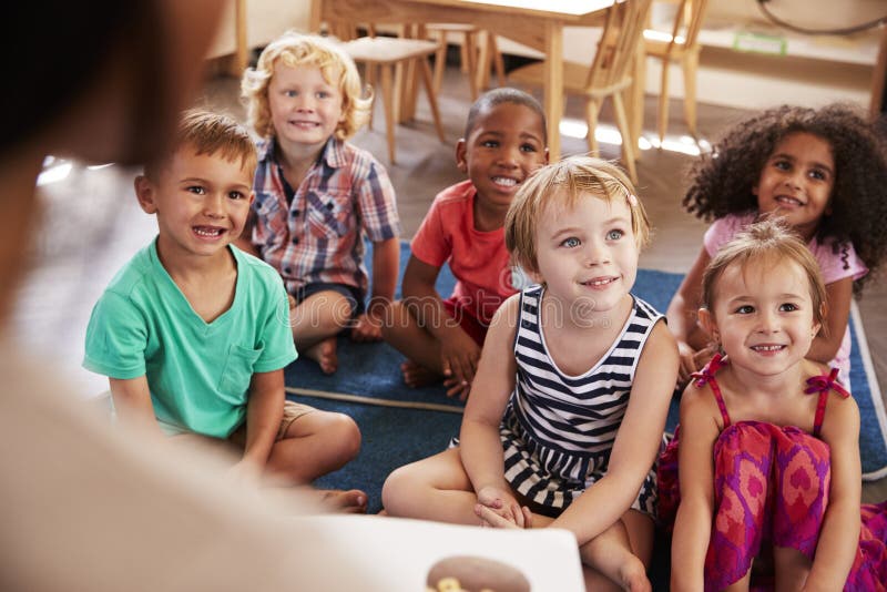 Учитель на школе Montessori читая к детям на времени рассказа стоковое изображение rf