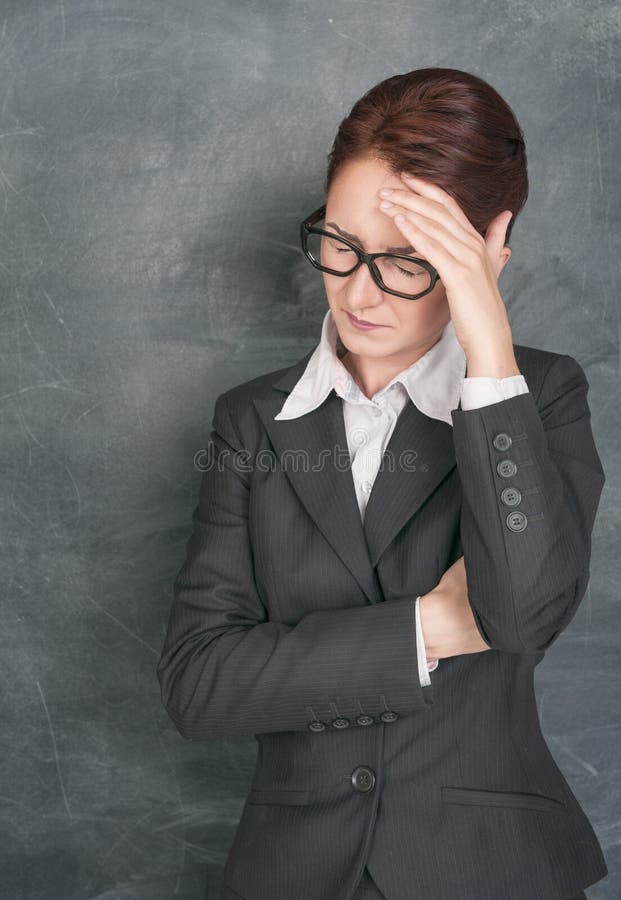 Teacher with headache on the school blackboard background. Teacher with headache on the school blackboard background