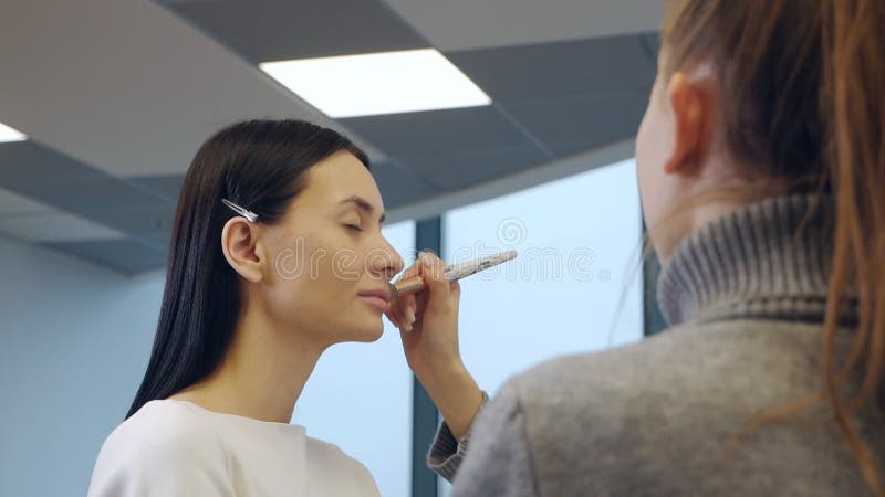 учитель макияжа со своим учеником. урок макияжа в школе красоты. класс master. студент делает макияж модели сток-видео