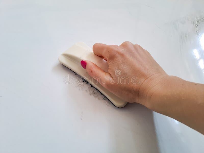 Teacher cleaning the chalkboard. Hand holding brush erase  on white background. Hand wiping blackboard. High quality photo. Teacher cleaning the chalkboard. Hand holding brush erase  on white background. Hand wiping blackboard. High quality photo