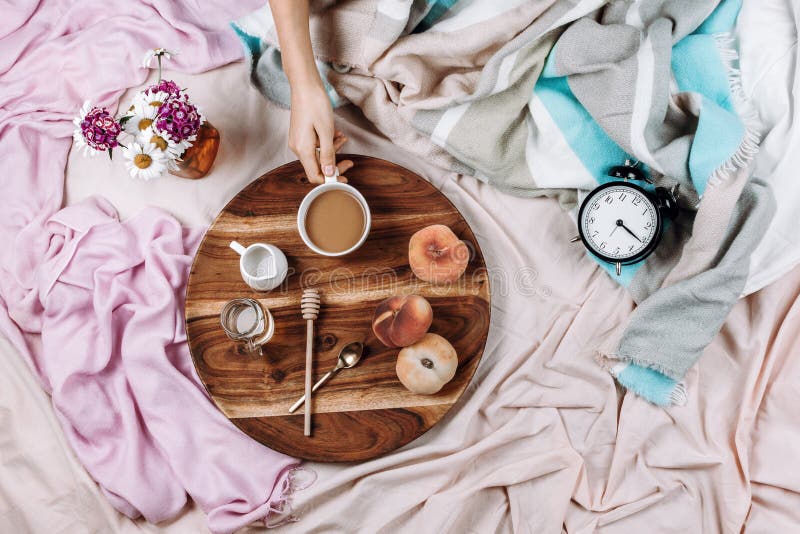 Уютные осень или зима flatlay деревянного подноса с чашкой кофе, персиками, сливочником с молоком завода, сиропом и ложками на па стоковое изображение rf Уютные осень или зима flatlay деревянного подноса с чашкой кофе, персиками, сливочником с молоком завода, сиропом и ложками на па стоковое изображение rf
