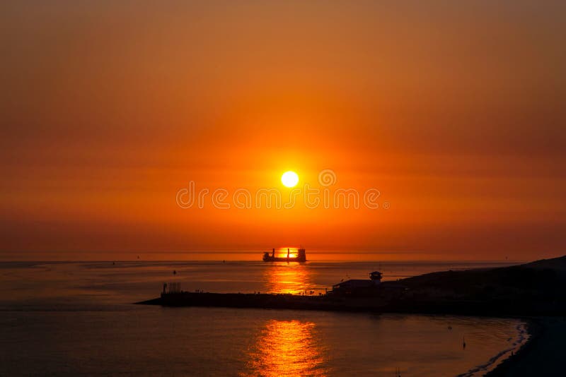 A fantastic sunset above the sea and a ship that sails in the reflection of the sun on the water. A fantastic sunset above the sea and a ship that sails in the reflection of the sun on the water.