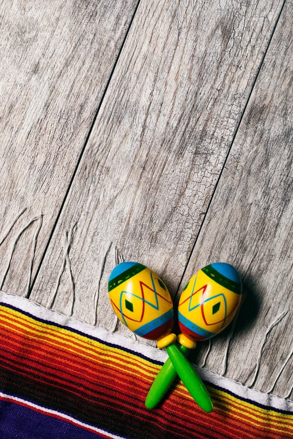 Фиеста: Maracas и Serape на деревянной предпосылке стоковое изображение rf Фиеста: Maracas и Serape на деревянной предпосылке стоковое изображение rf