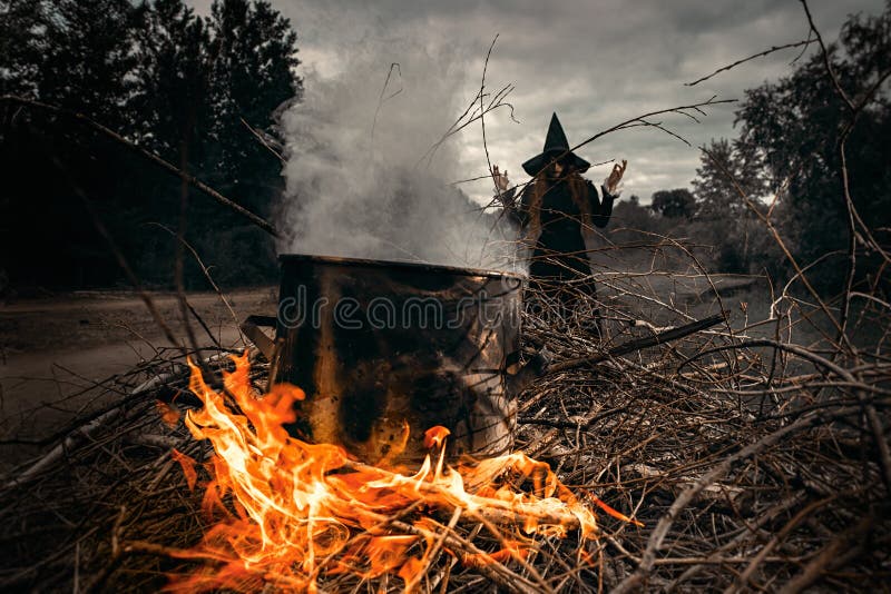 A portrait of an angry witch near the fire cooking spell. Magic, dark force, spell. A portrait of an angry witch near the fire cooking spell. Magic, dark force, spell