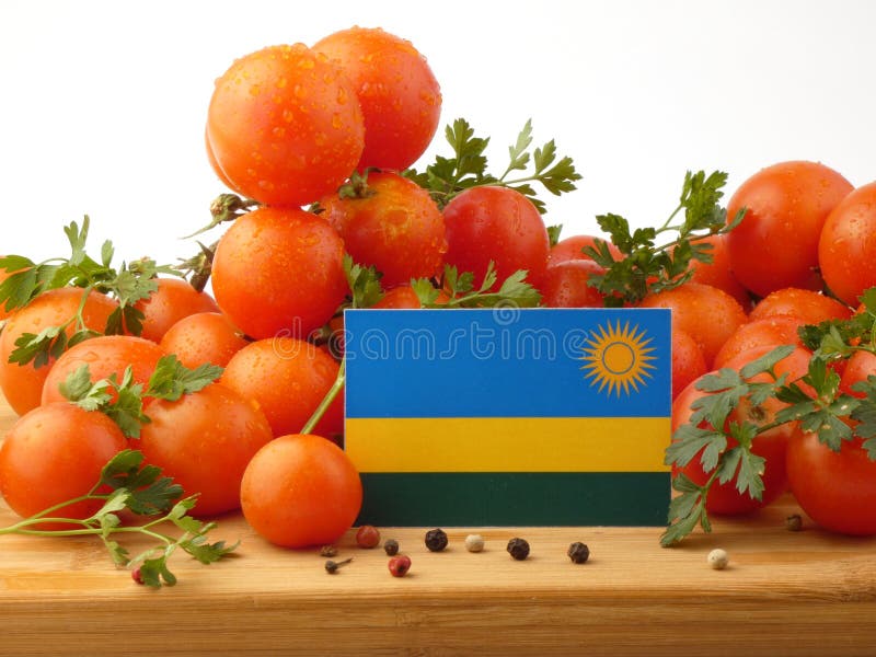 Флаг Руанды на деревянной панели при томаты изолированные на белизне стоковые изображения rf