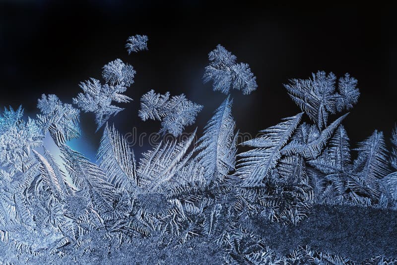 Ice flowers frozen blue window textured background. Macro view photography frost pattern. Cold winter weather xmas. Ice flowers frozen blue window textured background. Macro view photography frost pattern. Cold winter weather xmas.