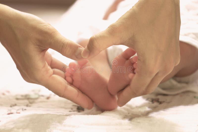 Форма сердца с newborn ногами для концепции влюбленности и заботы стоковое фото rf
