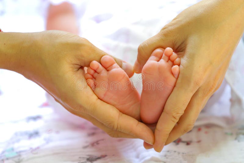 Форма сердца с newborn ногами для концепции влюбленности и заботы стоковое изображение