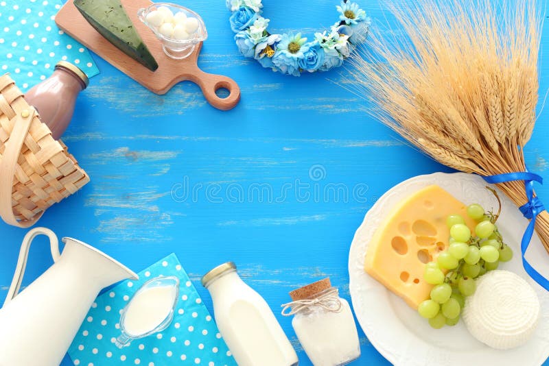 Фото взгляда сверху молочных продучтов над голубой деревянной предпосылкой Символы еврейского праздника - Shavuot стоковые фотографии rf