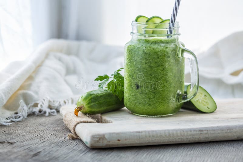 Фото зеленого smoothie огурца в опарнике с соломой на светлой предпосылке Свежий органический Smoothie Здоровье или диета вытрезв стоковое изображение rf Фото зеленого smoothie огурца в опарнике с соломой на светлой предпосылке Свежий органический Smoothie Здоровье или диета вытрезв стоковое изображение rf