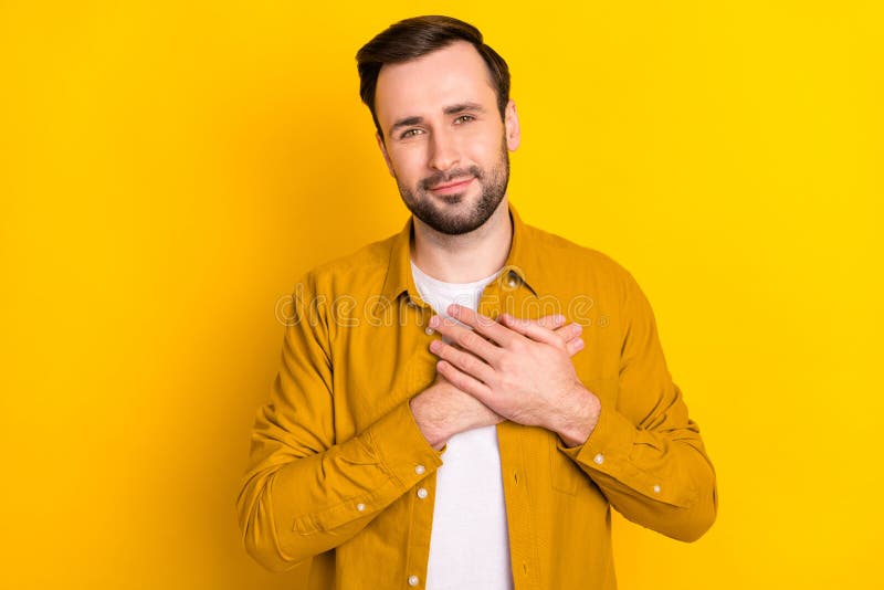 Photo of young man hands on chest appreciate thankful grateful isolated over yellow color background. Photo of young man hands on chest appreciate thankful grateful isolated over yellow color background.