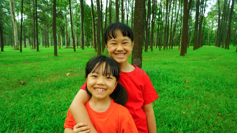 Photo background of 2 happy smiling girls playing relaxing in an outdoor park. Photo background of 2 happy smiling girls playing relaxing in an outdoor park