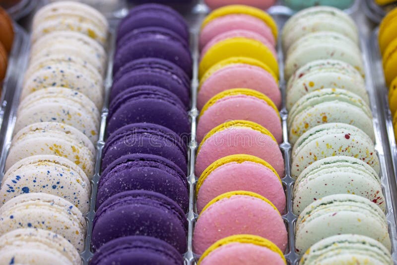 Французские macaroons аранжированы в ровных строках белого розового пурпура Торты сливк теста Macaroon, сладкий магазин печенья п стоковая фотография Французские macaroons аранжированы в ровных строках белого розового пурпура Торты сливк теста Macaroon, сладкий магазин печенья п стоковая фотография