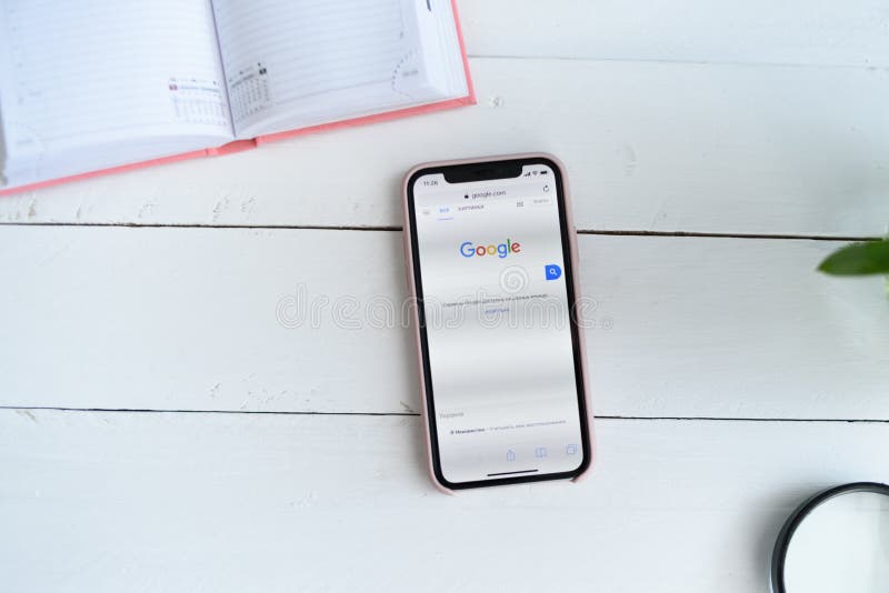 ХАРЬКОВ, УКРАИНА - 10-ое апреля 2019: IPhone x Яблока с Google место com на экране r Белый деревянный стол стоковые изображения