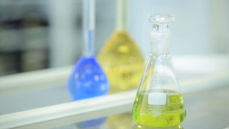 Химические флаконы с зеленой и голубой жидкостью на белой предпосылке Пробирки с красочным химическим реактивом лаборатория стоковое изображение Химические флаконы с зеленой и голубой жидкостью на белой предпосылке Пробирки с красочным химическим реактивом лаборатория стоковое изображение