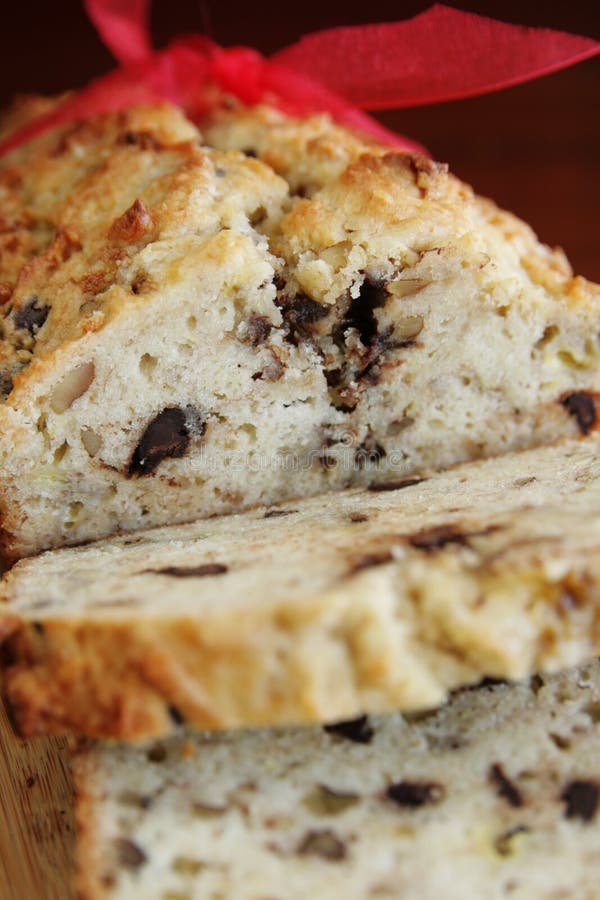 Close up of a warm banana bread in slice and red ribbon. Close up of a warm banana bread in slice and red ribbon