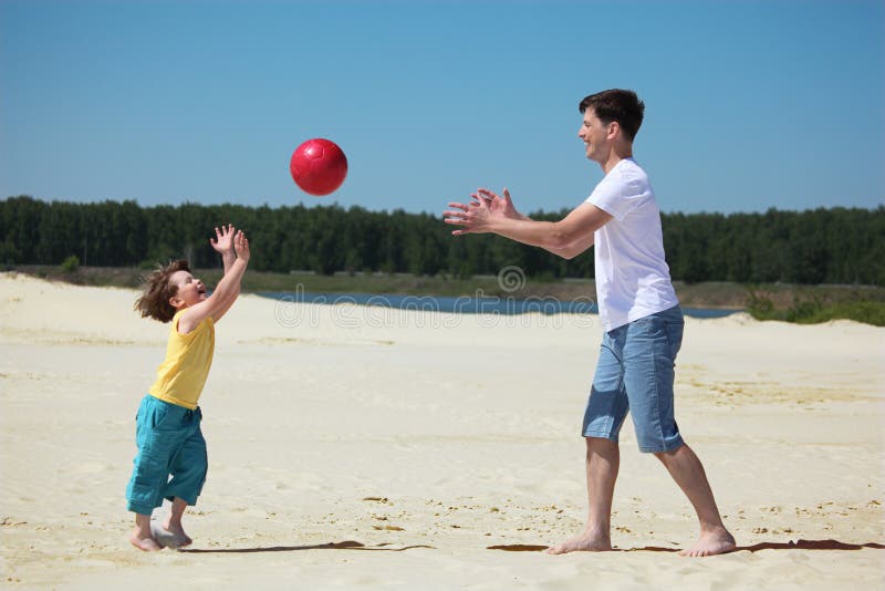 Son throws ball to father on sand, summer day. Son throws ball to father on sand, summer day