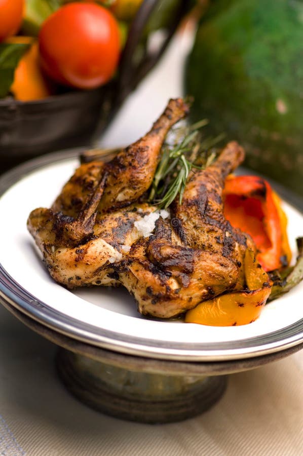 An image of rotisserie chicken with rosemary garnish. An image of rotisserie chicken with rosemary garnish