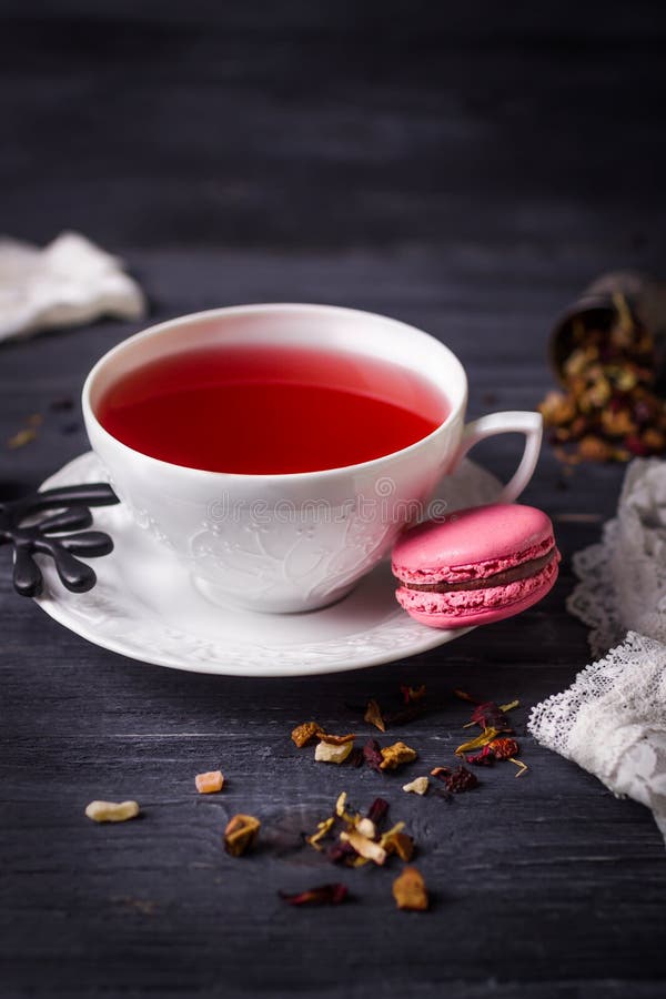 Чай плодоовощ и розовое macaron поленики на черной деревянной предпосылке Традиционные французские помадки стоковая фотография rf