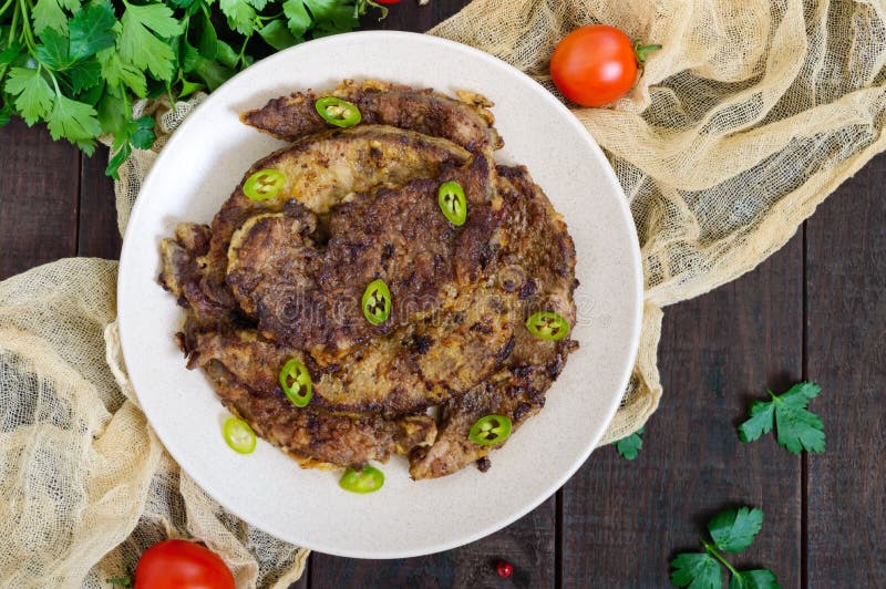Части зажаренной печени свинины на плите стоковые изображения